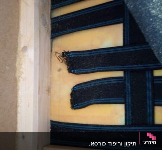 רצועות שחורות על גבי ריפוד צהוב בעבודת נגרות